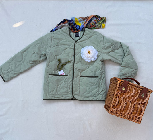 White peony flower pin on a sage green quilted jacket, styled with a silk scarf and wicker picnic basket, Bill & Evelyn